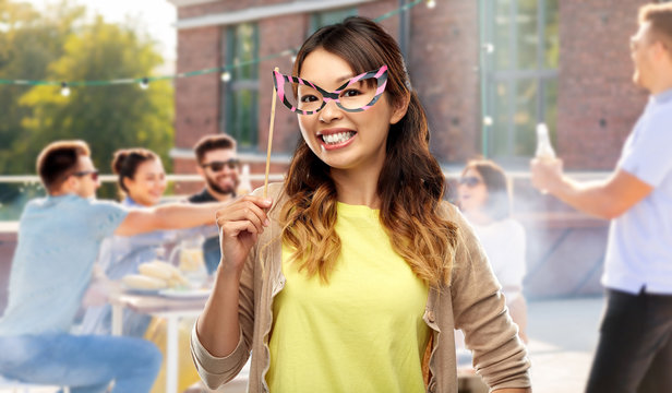 leisure and people concept - happy asian young woman with big glasses over rooftop party background