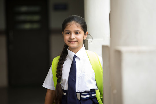 Portrait of schoolgirl standing at school campus