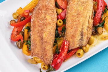 Grilled fish steak carp served with stewed chili peppers, olives, olives, greens and green pepper according to the Georgian recipe. Mediterranean Kitchen 