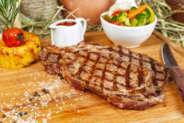 grilled beef steak according to Georgian recipe. Served with tomato sauce and fresh vegetable salad. National cuisine