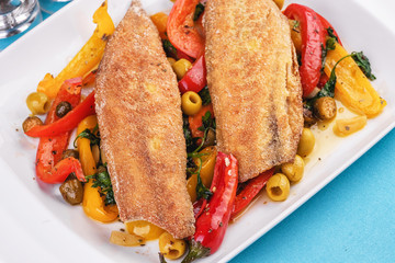 Grilled fish steak carp served with stewed chili peppers, olives, olives, greens and green pepper according to the Georgian recipe. Mediterranean Kitchen 