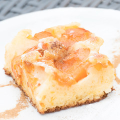 Delicious fruit flan with cinnamon and powdered sugar on a white tableware. Fresh, homemade sheet cake with fruits for a sweet dessert. 