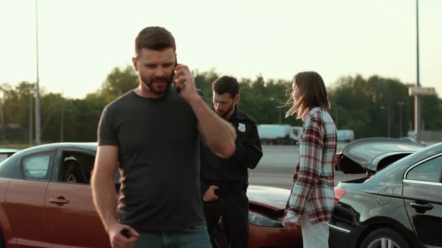 Portrait of baffled man calling his wife talking on smartphone outdoors. Driver asking for help speaking by cellphone against a car crash. Policeman and female driver girl talking and arguing.