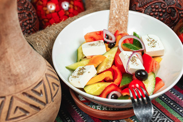 Greek salad according to Georgian recipe with pepper, onion and cheese, seasoned with olive oil and spices and crispbread. National cuisine