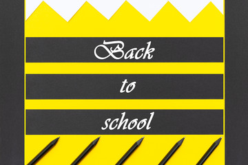 White stickers with black pencils lined with a geometric pattern on a background of yellow with black stripes.