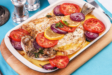 Seafood, Mediterranean cuisine, European dish. Baked entirely in foil fish with onion rings, pimodori, zucchini and baclazans under fragrant spices. Caucasian national cuisine