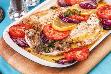 Seafood, Mediterranean cuisine, European dish. Baked entirely in foil fish with onion rings, pimodori, zucchini and baclazans under fragrant spices. Caucasian national cuisine