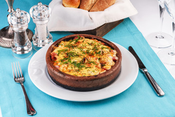 European cuisine, Mediterranean dish. Stew of meat, vegetables and seafood, baked in a pot under a cheese crust