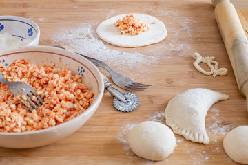 Making panzerotto, traditional Apulian food. Dough and ingredients on a wooden chopping board