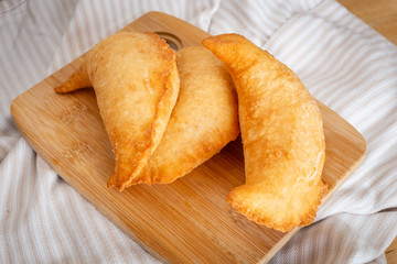 Fried panzerotto on a wooden chopping board. Typical food of Puglia, Italy