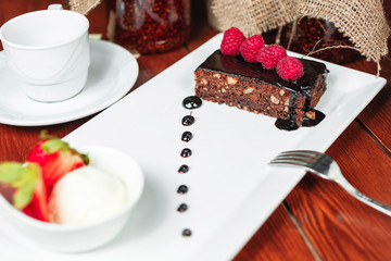 chocolate cake with nuts, sprinkled with sweet sauce with berries