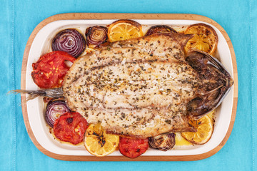 Seafood, Mediterranean cuisine, European dish. Baked entirely in foil fish with onion rings, pimodori, zucchini and baclazans under fragrant spices. Caucasian national cuisine