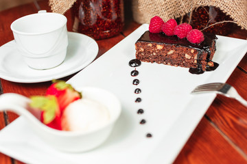 chocolate cake with nuts, sprinkled with sweet sauce with berries