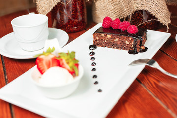 chocolate cake with nuts, sprinkled with sweet sauce with berries