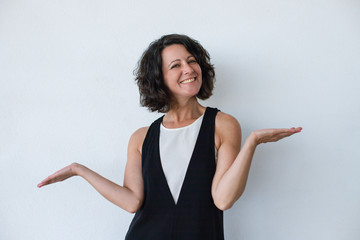 Smiling woman gesturing with hands. Attractive middle aged brunette woman with curly hair gesturing...