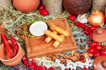 Georgian appetizer - cheese sticks, deep fried in an obolochke of puff pastry. Served with tartar sauce and greens, cabbage. National cuisine