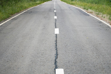 Grey shabby car asphalt road with white dividing lines