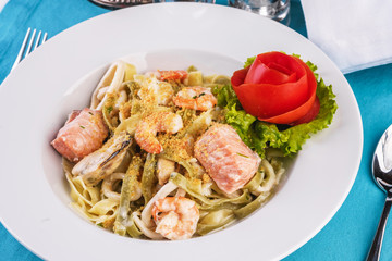  Mediterranean dish, Georgian recipe. Creamy pasta with shrimps, crab meat, seafood, squid rings, tomatoes, basil, greens and cheese.