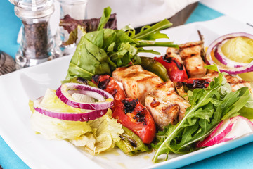  Seafood, Mediterranean cuisine, European dish. salad of assorted fish pieces grilled, with grilled vegetables - with onion rings, red and green pepper, chili pepper, greens, cheese, mushrooms 