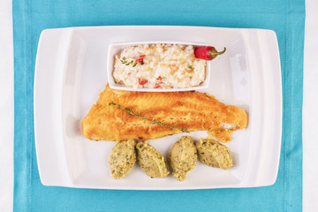 Fried fish steak carp served with greens, chili pepper, boiled rice, rosemary, thyme and mashed potatoes with dill according to the Georgian recipe. Mediterranean Kitchen