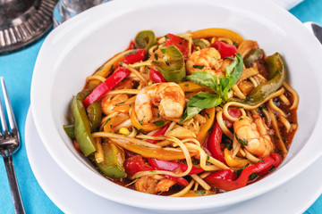 Mediterranean dish, Georgian recipe. Pasta with shrimps, red and green pepper, basil