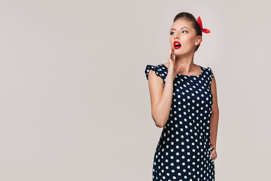 portrait of surprised pin up woman in polka dot dress. cute girl in retro style. copy space for text