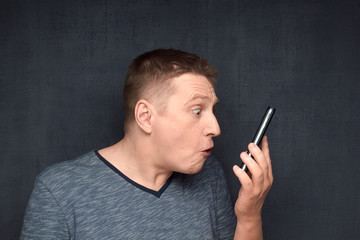 Portrait of surprised man looking on phone screen