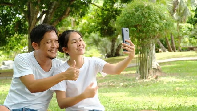 Happy young couple taking selfie by mobile phone in garden