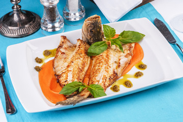  Sea fish steak with basil and green pepper on a pumpkin puree pillow according to the Georgian recipe. Mediterranean cuisine