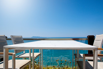 White table background with ocean and sunny blue sky view.