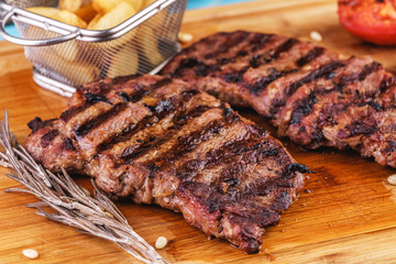 grilled beef steak with grilled pepper, onion rings and tomatoes. served with potato wedges and thyme. according to the Georgian recipe