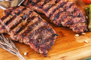 grilled beef steak with grilled pepper, onion rings and tomatoes. served with potato wedges and thyme. according to the Georgian recipe