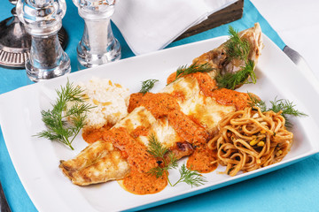 Baked fish in batter with caviar sauce, served with noodles in soy sauce, with rice and corn according to the Georgian recipe. Mediterranean Kitchen 