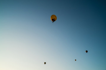 Hot air balloons high in the air. European balloon festival in Spain. Free flow of big colourful balloons flying in the event sky. Beautiful landscapes and evening light. Summer adventures in Spain 
