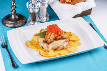 Seafood, Mediterranean cuisine, European dish. Sea salmon Fish steak with greens, country-style fried potatoes, cheese and cream sauce. Caucasian national cuisine