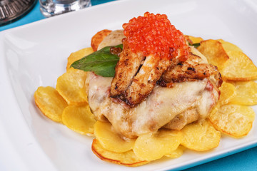 Seafood, Mediterranean cuisine, European dish. Sea salmon Fish steak with greens, country-style fried potatoes, cheese and cream sauce. Caucasian national cuisine