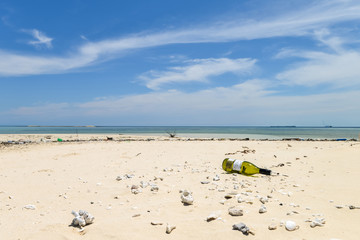 single empty bottle of wine on a lost beach, shot on Mataking island, Semporna, Sabah, Malaysia