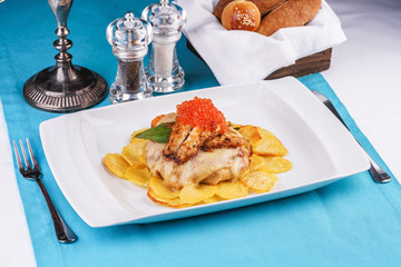 Seafood, Mediterranean cuisine, European dish. Sea salmon Fish steak with greens, country-style fried potatoes, cheese and cream sauce. Caucasian national cuisine