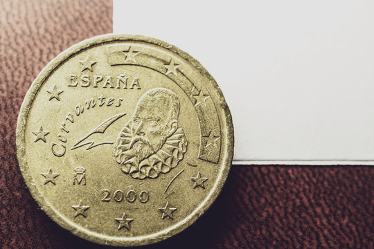 the corner of a white sheet of paper and a coin with the famous Spanish
