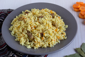 Rice with small pieces of meat and carrot on the grey plate