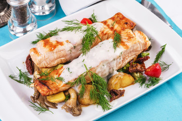 Seafood, Mediterranean cuisine. Grilled salmon fish steak with grilled vegetables and oyster mushrooms. Caucasian kitchen