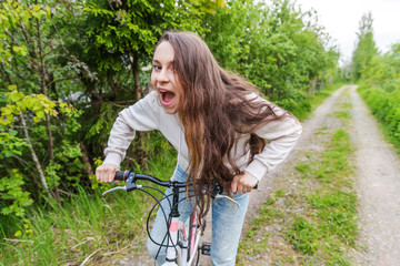 Fototapeta na wymiar Young woman riding bicycle in summer city park outdoors. Active people. Hipster girl relax and rider bike. Cycling to work at summer day. Bicycle and ecology lifestyle concept