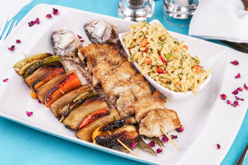 Mediterranean dish, Georgian recipe. Baked chicken skewers with lemon, vegetables, pepper, zucchini, eggplants and grilled tomatoes with spices, and steamed rice