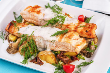 Seafood, Mediterranean cuisine. Grilled salmon fish steak with grilled vegetables and oyster mushrooms. Caucasian kitchen