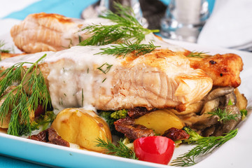 Seafood, Mediterranean cuisine. Grilled salmon fish steak with grilled vegetables and oyster mushrooms. Caucasian kitchen
