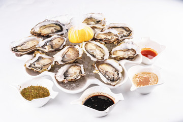 Mediterranean dish, European cuisine. Fresh raw mussels served with lemon, and assorted sauces- oyster, soy, creamy, mustard, red chili pepper sauce