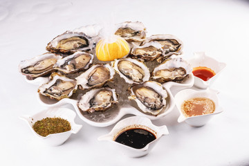 Mediterranean dish, European cuisine. Fresh raw mussels served with lemon, and assorted sauces- oyster, soy, creamy, mustard, red chili pepper sauce