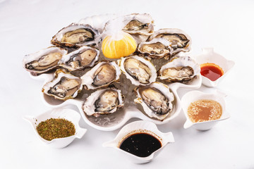 Mediterranean dish, European cuisine. Fresh raw mussels served with lemon, and assorted sauces- oyster, soy, creamy, mustard, red chili pepper sauce