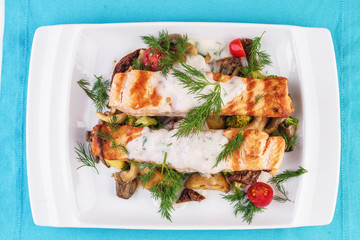 Seafood, Mediterranean cuisine. Grilled salmon fish steak with grilled vegetables and oyster mushrooms. Caucasian kitchen