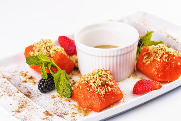 Turkish dessert recipe. Pumpkin baked in honey with nuts, served with scaram sauce and berries - strawberries, blueberries